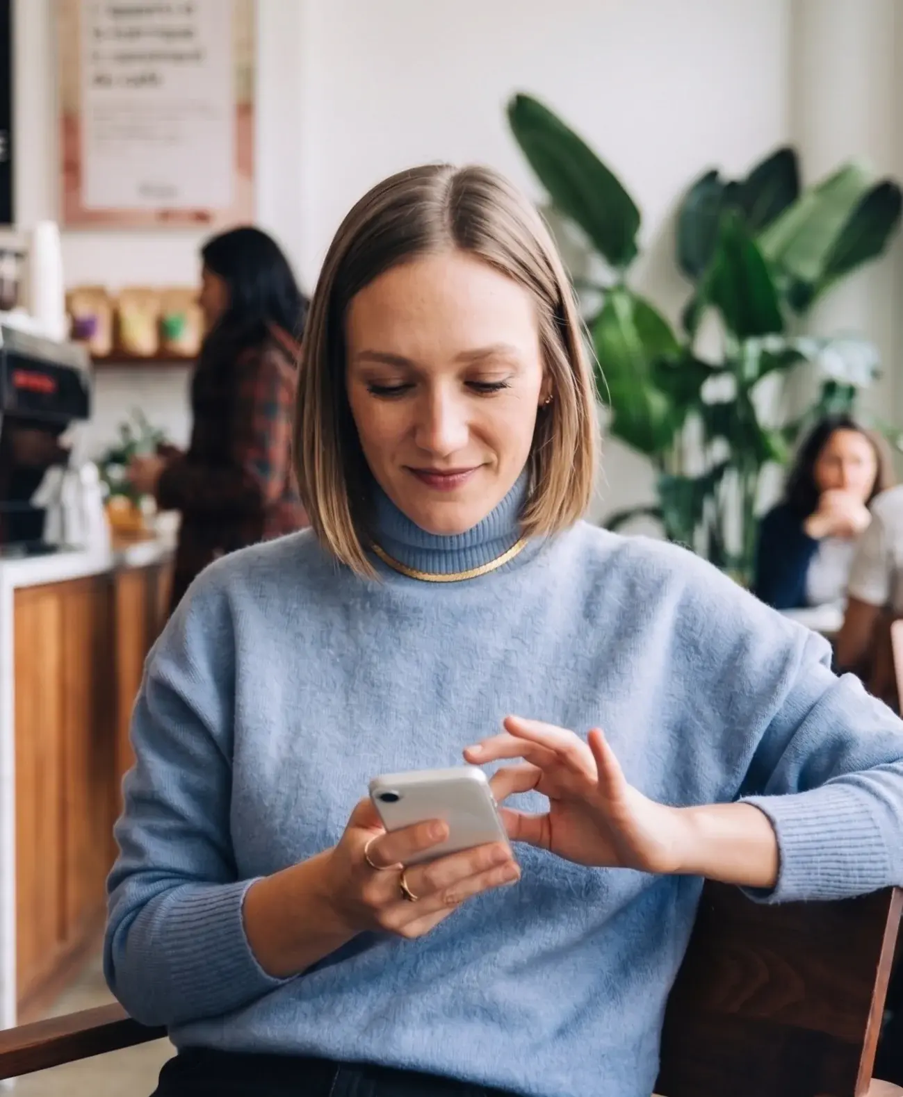 Patient using her phone at a café table